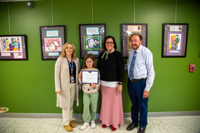 Children pose with their artwork.