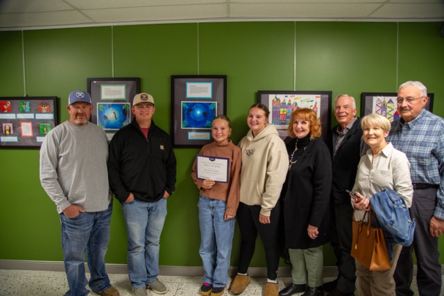 Family poses with child in front of artwork.