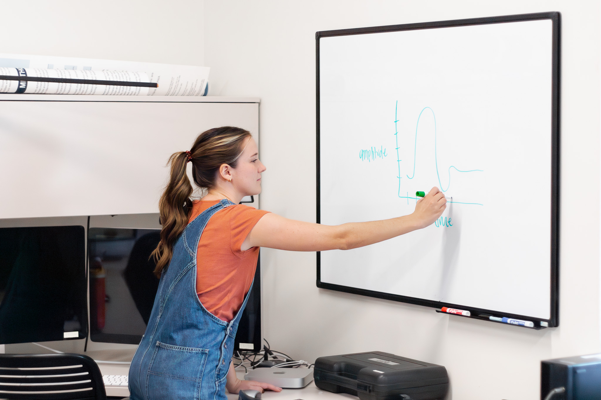 A woman writing on a whiteboard