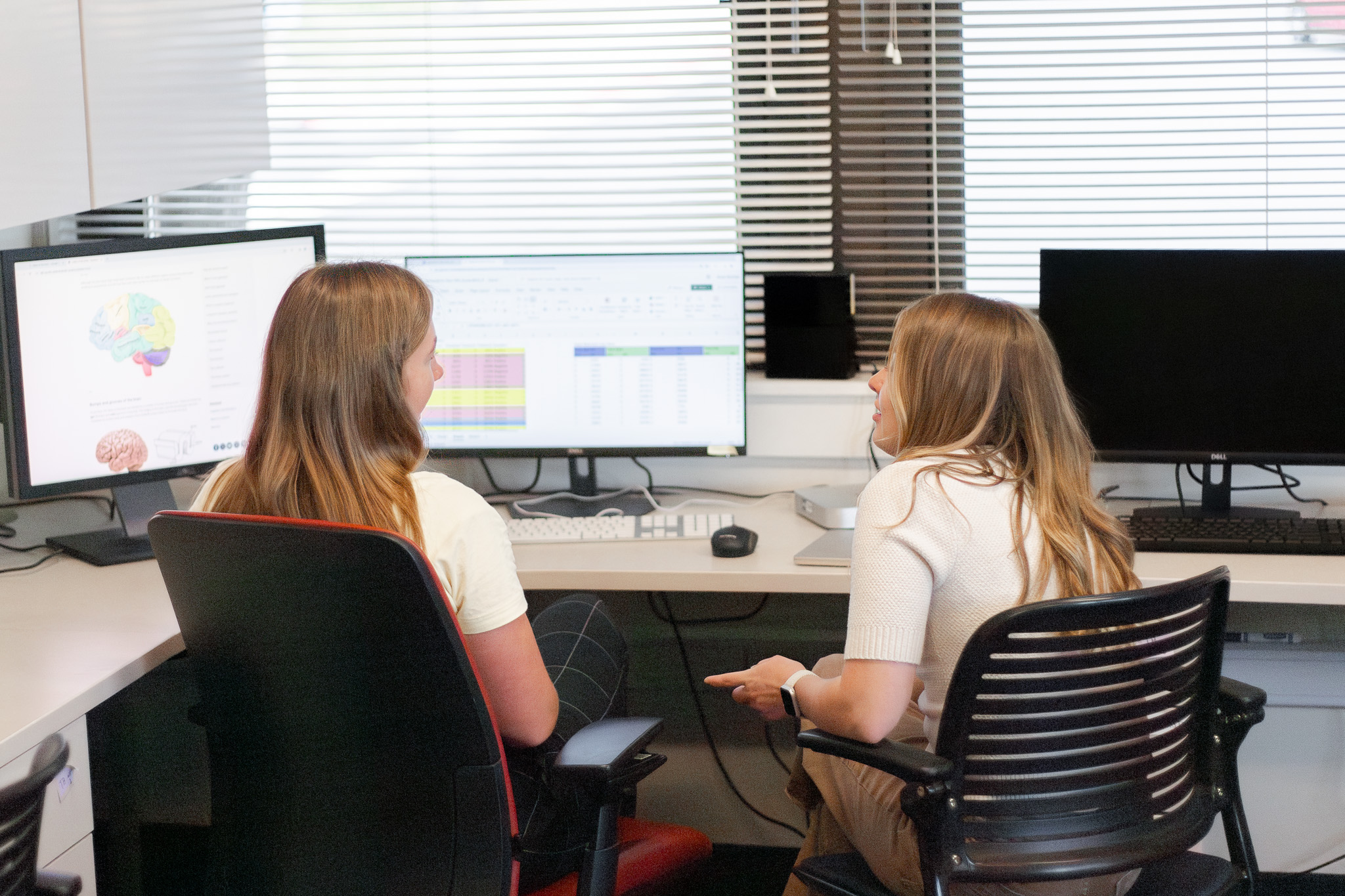 Two women talking in front of a screen