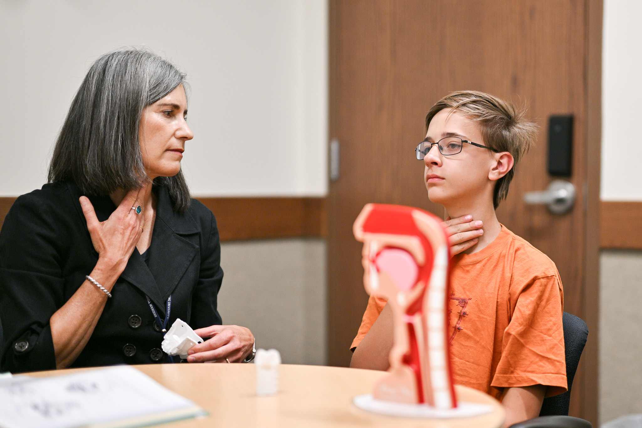 A woman helping a child speak