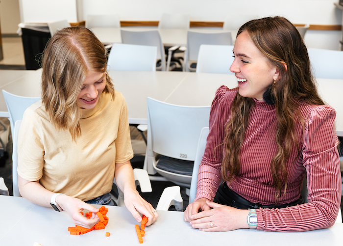 Two girls sitting at a table doing a learning activity