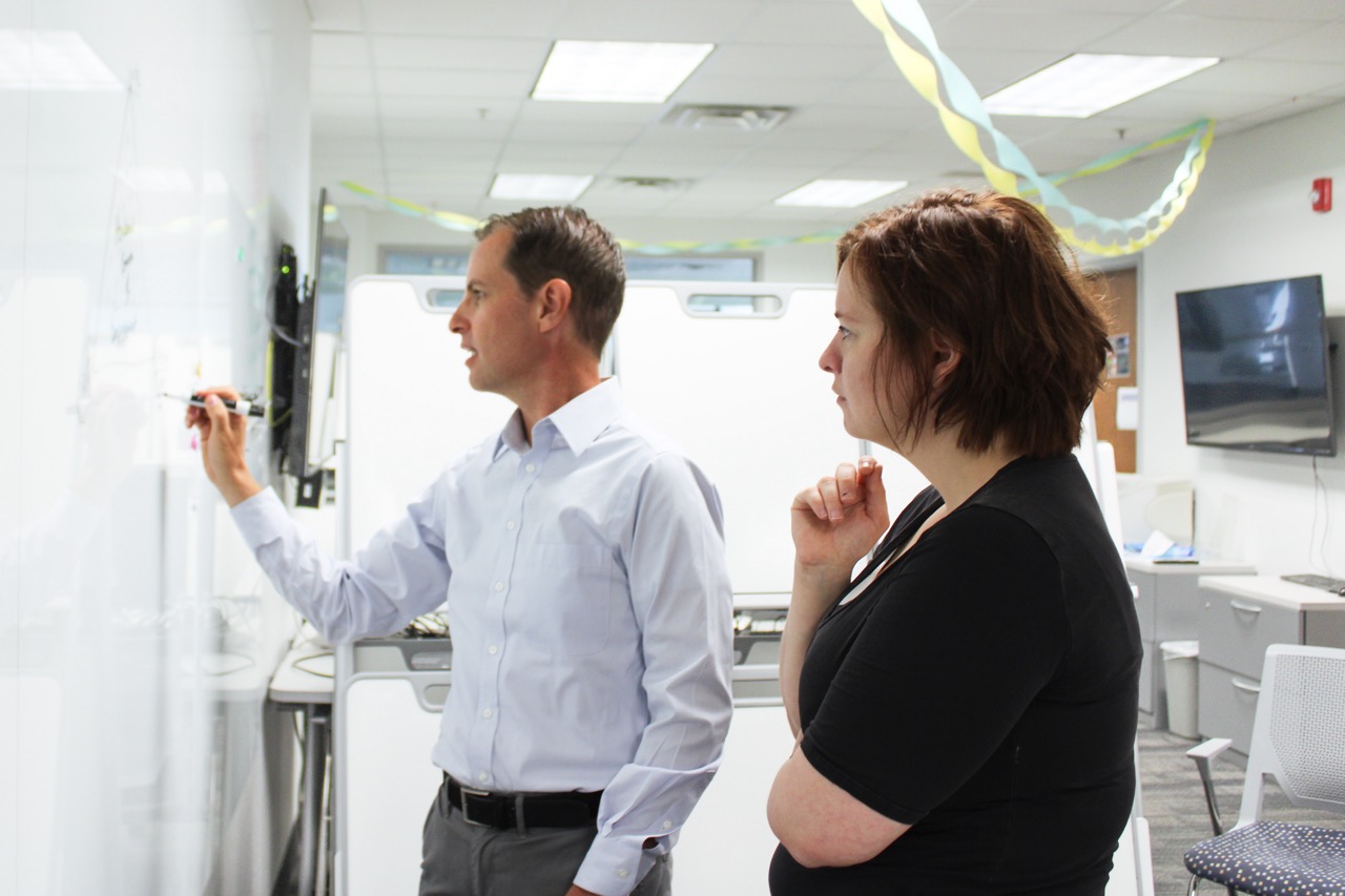 man writing on whiteboard
