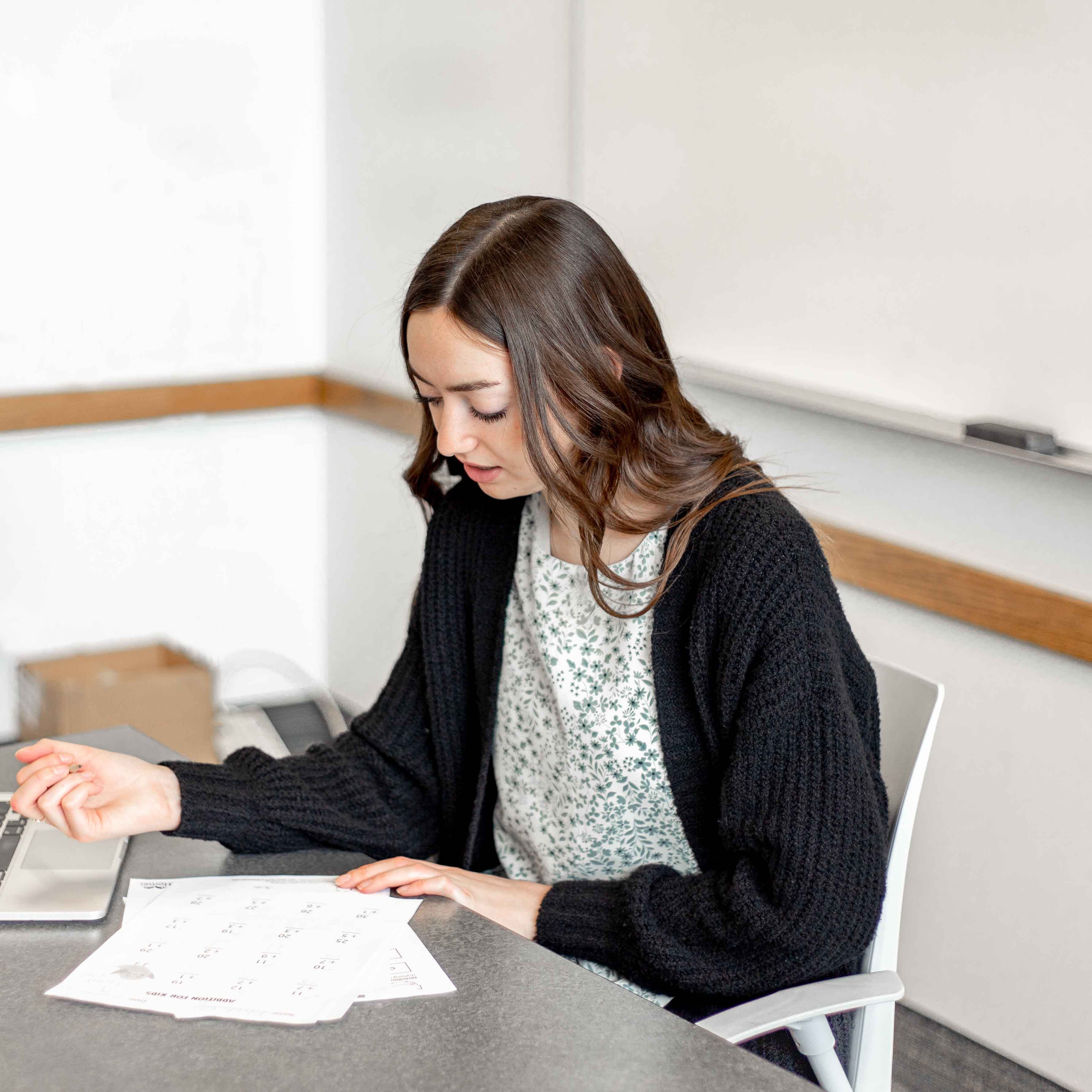 woman annotating paper at desk