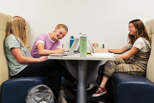 Three women talking at table