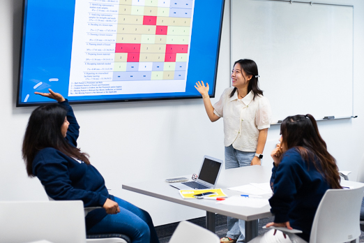 Students around a table viewing the material on the television