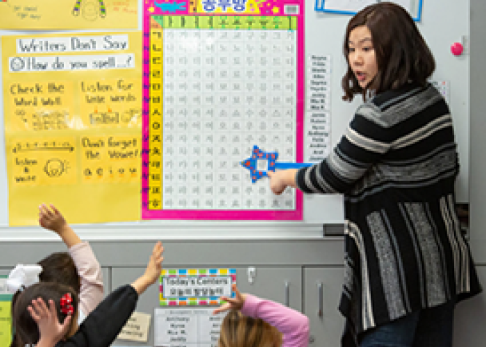 Teacher in front of the classroom teaching her students Korean