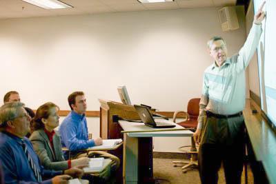 presenter pointing at projector screen