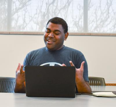 Man talking in front of a computer