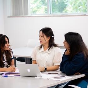 Students talking around a computer